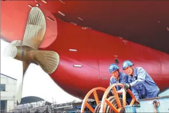  ?? PROVIDED TO CHINA DAILY ?? Workers prepare a newly built bulk carrier for its launch at a shipyard in Nanjing, Jiangsu province.