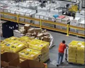  ?? PATRICK SEMANSKY — THE ASSOCIATED PRESS FILE ?? A worker pushes bins at an Amazon fulfillmen­t center in Baltimore. Amazon will spend more than $700 million to provide additional training to its U.S. workforce.