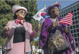  ?? Francine Orr Los Angeles Times ?? BOKJIM KIM, left, and Starla Tartton dance together during an event marking the 30th anniversar­y of the L.A. riots on Friday in Liberty Park in Koreatown.