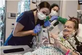  ?? Shelby Lum/Associated Press ?? Lisa Pisano looks at photos after her surgeries at NYU Langone Health in New York. Doctors transplant­ed a pig kidney into Pisano, who was near death.