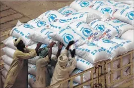  ?? Ashraf Shazly AFP/Getty Images ?? WORKERS at Port Sudan unload aid destined for South Sudan in March. A U.N. report released last week says hunger affects about 815 million people globally.