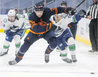  ?? THE CANADIAN PRESS ?? Edmonton Oilers’ Leon Draisaitl (29) is chased by Vancouver Canucks’ Quinn Hughes (43) and Matthew Highmore (15) during second-period action in Edmonton on Thursday. The Canucks won 6-3.