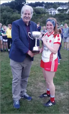  ??  ?? Tinahely captain Ciara Stokes accepts the league cup from Leinster LGFA President Dominic Leech.