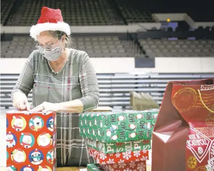  ?? KRISTEN ZEIS/STAFF ?? Patti Peterson, of Newport News, wraps gifts for children chosen for the Angel Tree project at the Hampton Coliseum in Hampton on Friday. Children are selected by social services and Hampton Healthy Families.