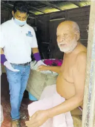  ??  ?? Dr Babu attends to Belfield resident, former shoemaker, “Cliffie”, whom he also gave a care package.