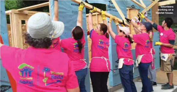  ??  ?? Volunteers working on a Habitat house.