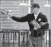  ?? AP/THE Wichita EAGLE/BRIAN CORN ?? A letter carrier delivers mail Wednesday in Wichita, Kan. Under a U.S Postal Service plan to cut costs, regular Saturday mail delivery would end.