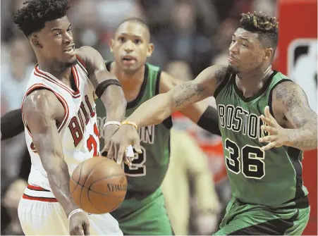 ?? AP PHOTO ?? SLAP SHOT: Marcus Smart knocks the ball away from Jimmy Butler in the fourth quarter of the Celtics’ loss to the Bulls last night in Chicago.