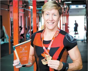  ?? PHOTO AGENCE QMI, TOMA ICZKOVITS ?? L’haltérophi­le Isabelle Gauthier expose fièrement sa médaille et son trophée de nouvelle championne du monde dans la catégorie Masters, remporté à Barcelone.