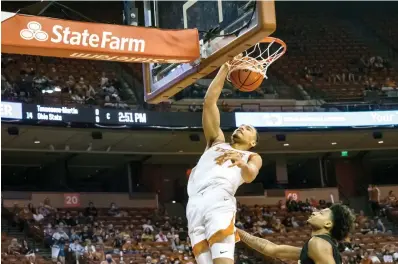  ?? AP Photo/Michael Thomas ?? ■ Texas forward Dylan Disu (4) dunks the ball against Alabama State forward Gerald Liddell Wednesday during the second half of an NCAA college basketball game in Austin. Texas won 68-48.