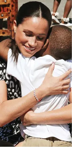  ??  ?? Hugs: The duchess greets a young boy yesterday