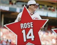  ?? AP ?? Former Cincinnati Reds player Pete Rose holds his place marker during a ceremony to honor the 1976 World Series champion team, before the Reds’ baseball game against the San Diego Padres June 24, 2016, in Cincinnati.