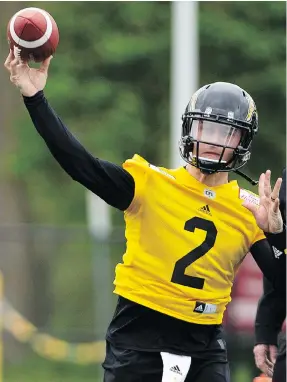  ?? PETER POWER/THE CANADIAN PRESS ?? Quarterbac­k Johnny Manziel practises with teammates during Tiger-Cats training camp in Hamilton on Sunday.