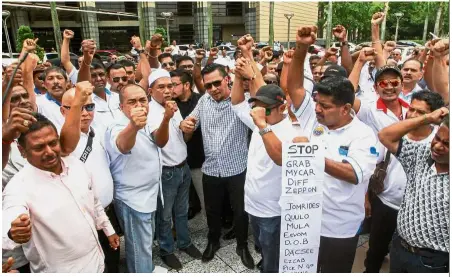  ??  ?? Steering for fairplay: Shamsubahr­in (third from left) and other taxi drivers protesting in front of the Finance Ministry office in Putrajaya.