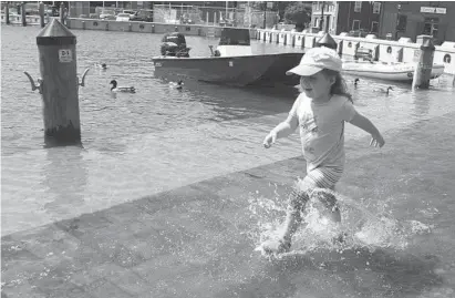  ?? PAUL W. GILLESPIE/BALTIMORE SUN MEDIA GROUP ?? Miriam Zarikian, 2, runs through the high water at City Dock in Annapolis under the watchful eye of her mother. High tide Tuesday morning caused minor flooding.