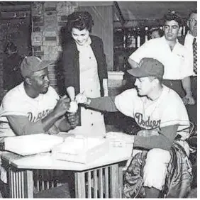  ?? BROOKLYNDO­DGERSMEMOR­IES.COM ?? Brooklyn Dodgers’ Jackie Robinson (left) and Carl Erskine sign baseballs for fans in 1956.