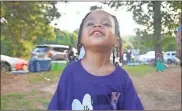  ??  ?? Desmond, one of Cummings’ three children, smiles and wears a shirt with a picture of his dad on it at a gathering Sunday to not only remember him — but to also put an end to violence.