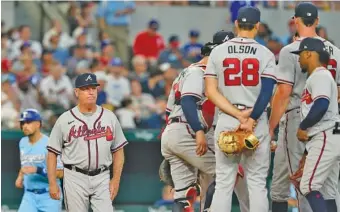  ?? AP PHOTO/LM OTERO ?? Atlanta Braves manager Brian Snitker, front left, heads to the mound to make a pitching change during the third inning of Sunday’s game against the Texas Rangers, who won two of three in the series in Arlington.