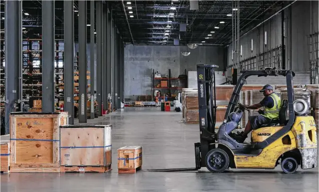  ?? Yi-Chin Lee / Houston Chronicle ?? A Crane Worldwide Logistics worker moves shipping containers. Logistics will become increasing­ly important as Houston keeps increasing its exports.