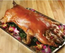  ?? CRAIG LEE/SAN FRANCISCO CHRONICLE/THE ASSOCIATED PRESS ?? Wilson Martinito of Wilson’s Haus of Lechon at 365 Wilson Ave., cooks 40-pound pigs with lemongrass, green onions and aromatics in the cavity.