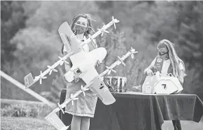  ?? PROVIDED BY WING ?? Girl Scouts Gracie Walker and Alice Goerlich help prepare orders with Wing for drone cookie deliveries in Christians­burg, Va.
