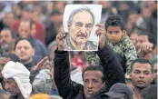  ??  ?? FAN CLUB: A man holds a poster of Khalifa Haftar during a rally demanding Gen Haftar take over in 2017.