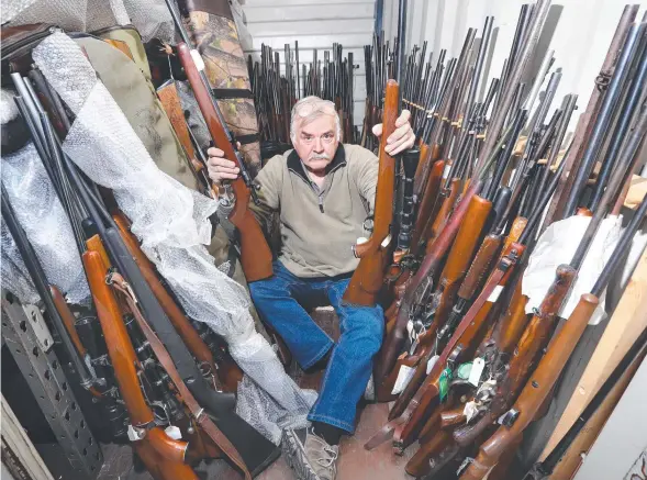  ?? Picture: GLENN FERGUSON ?? BACK IN BUSINESS: Rod Haugh with some of the hundreds of rifles that have been returned to The Outdoor Sportsman.