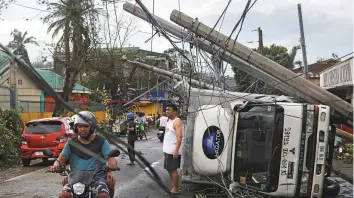  ?? Reuters ?? Residents seen after Typhoon Kammuri hit Camalig town in Philippine­s yesterday. Authoritie­s were still assessing the storm’s impact.