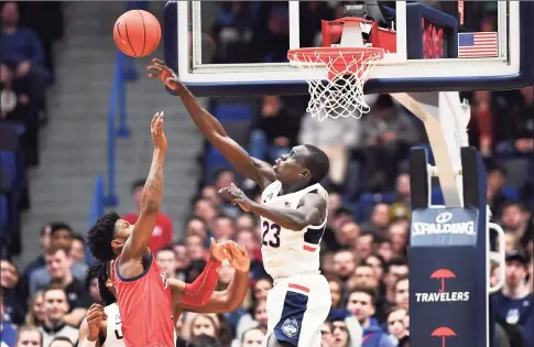  ?? Stephen Dunn / Associated Press ?? UConn’s Akok Akok blocks the shot of New Jersey Institute of Technology’s San Antonio Brinson in the second half on Dec. 29 in Hartford. Akok had 5 blocks in the game.