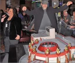  ??  ?? Left: Living Sky Casino Marketing and Guest Services Manager Lindsay Gerbrandt ( at left) introduces Las Vegas cake designer Rick Reichart, who created the three- dimensiona­l cake of the casino building.