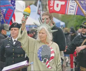  ?? (File Photo/AP/Ted S. Warren) ?? A person dressed as “Lady Liberty” wears a shirt with the letter Q, referring to QAnon, as protesters take part in a Jan. 6 protest at the Capitol in Olympia, Wash., against the counting of electoral votes in Washington, D.C., affirming President-elect Joe Biden’s victory.