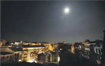  ?? Carolyn Cole Los Angeles Times ?? THE MOON shines brightly over downtown Kyiv, helping fend off darkness in Ukraine’s capital Wednesday. The city has faced rolling blackouts to protect an energy infrastruc­ture damaged by Russian missile strikes.