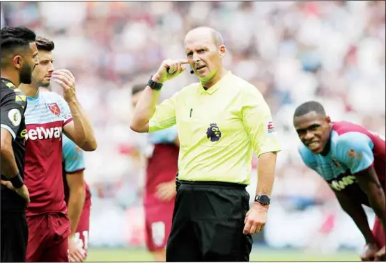  ?? (AP) ?? Referee Mike Dean waits for a VAR decision on a penalty during the English Premier League soccer match between West Ham United and Manchester City at London stadium in London on
Aug 10.
