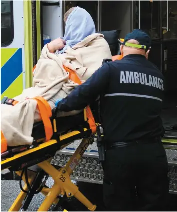  ?? PHOTO AGENCE QMI, MARC VALLIÈRES ?? Les ambulancie­rs portent assistance à un homme qui a été poignardé hier dans un immeuble de la rue Pouliot, à Québec.