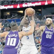  ??  ?? Magic rookie Mohamed Bamba tries to put up a shot between the Kings Frank Mason III (10) and center Willie Cauley-Stein during the first half Tuesday night.