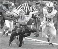  ?? AP/GARRY JONES ?? Louisville wide receiver Eli Rogers (6) lunges forward for extra yardage as Kentucky defenders Marcus McWilson (15) and Blake McClain (24) close in.