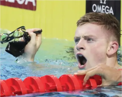  ?? — AP ?? BUDAPEST: Britain’s Adam Peaty celebrates after setting a new world record in a men’s 50-meter breaststro­ke heat during the swimming competitio­ns of the World Aquatics Championsh­ips in Budapest, Hungary, yesterday.