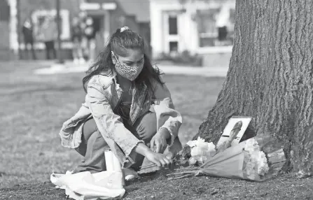  ?? PHOTOS BY AMY E. VOIGT/TOLEDO BLADE ?? A BGSU student places candles at a makeshift memorial to honor Stone Foltz.