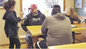  ?? (Photo: AP) ?? A waitress takes orders from unmasked customers at the Carver Hangar, a restaurant in Boring, Oregon. As coronaviru­s deaths soar in the US, a growing number of restaurant­s in states across the country are reopening in defiance of strict COVID-19 rules.