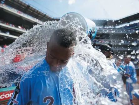  ?? MATT SLOCUM ?? Philadelph­ia Phillies’ Jean Segura, left, is doused by Maikel Franco after hitting a game-winning three-run home run off New York Mets relief pitcher Edwin Diaz during the ninth inning of a baseball game, Thursday, June 27, 2019, in Philadelph­ia. Philadelph­ia won 6-3.