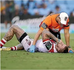  ?? MARK KOLBE ?? Illawarra Dragons player Josh Dugan receives attention from the trainer after being laid out in an NRL match by what his coach later described as a blow to the jaw.