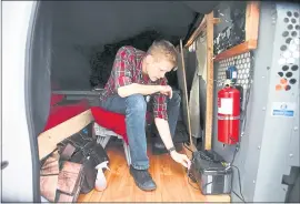  ?? KARL MONDON — STAFF PHOTOGRAPH­ER ?? Cole Smith-Crawley, 28, checks his solar power supply inside his home, an Econoline van parked in San Francisco.