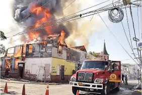  ?? E RROL CROSBY ?? Firefighte­rs battle yesterday’s blaze at the corner of Duke and Sutton streets in central Kingston.