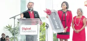  ??  ?? Mrs Juliet Holness, MP (centre), receives a gift created by the Bonny Gate Women’s Group in St Mary and presented by members of the Digicel Foundation during their 15th anniversar­y ceremony.