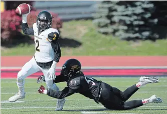  ?? PETER LEE WATERLOO REGION RECORD ?? Waterloo Warriors’ Gordon Lam, left, is about to be tackled in the backfield by Gryphons’ A.J. Allen on Saturday afternoon at Alumni Stadium in Guelph. The Gryphons won the game, 47-44 in double overtime.