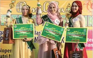  ?? NURUL KOMARIYAH/JAWA POS ?? SASAR WARGA URBAN: Duta Fatayat NU Gresik Irva Zahrotul diapit peringkat ketiga Wahidah Ma’rifatun (kiri) dan runner-up Putri Balqis (kanan) di Putri Mijil pada Minggu malam.