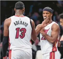  ?? MARY ALTAFFER/AP ?? Heat forward Jimmy Butler, right, and center Bam Adebayo celebrate after a win over the Nets in overtime Jan. 15 in New York.