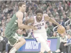  ?? USA TODAY Sports photo ?? Philadelph­ia 76ers center Joel Embiid (right) drives for the basket against Milwaukee Bucks center Brook Lopez during the fourth quarter at Fiserv Forum. —