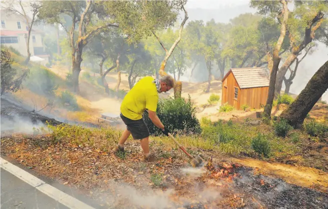  ?? Carlos Avila Gonzalez / The Chronicle ?? Kenny Wainright, whose family has run the Nichelini Winery for 130 years, puts out a spot fire near his greatgrand­parents’ cabin at the winery, which was threatened by the Hennessey Fire near St. Helena in August.