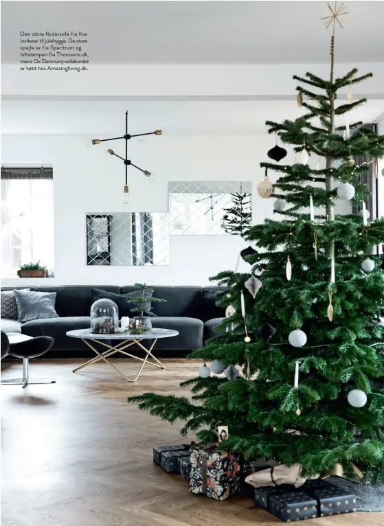  ??  ?? Den store flydersofa fra Ilva inviterer til julehygge. De store spejle er fra Spectrum og loftslampe­n fra Thomsons.dk, mens Ox Denmarq-sofabordet er købt hos Amazingliv­ing.dk.